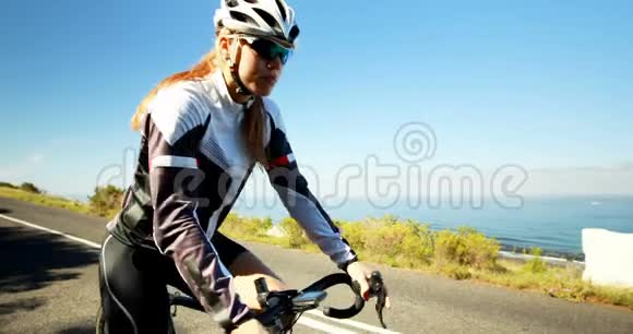 骑自行车的女性在乡村公路上骑自行车视频的预览图