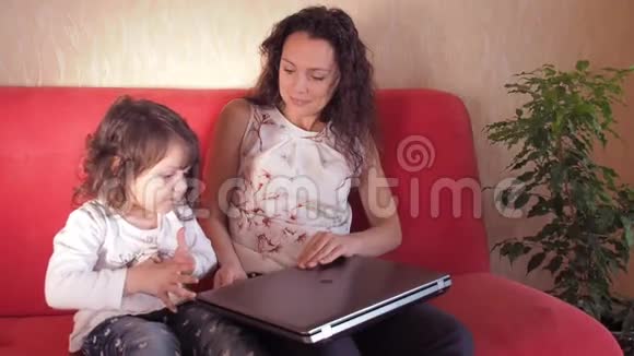 一个带着孩子在笔记本电脑上玩的女孩视频的预览图