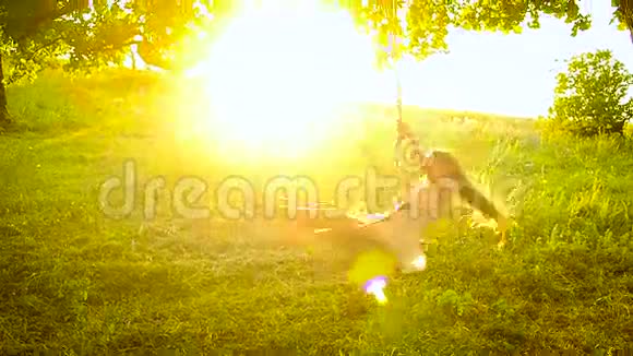 女孩在阳光下摇摆在树上摇摆视频的预览图