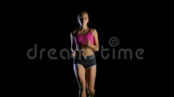 年轻女子在黑色背景上奔跑视频的预览图