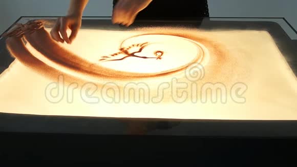 用沙子画画在白色的屏幕上画沙子沙滩艺术家双手画视频的预览图