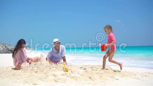 一家人带着两个孩子在热带海滩上建造沙堡视频的预览图