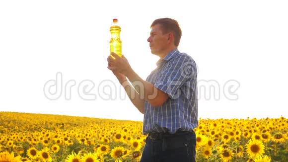 老人阳光农夫葵花油概念农业农夫手里拿着一个塑料瓶葵花籽油视频的预览图