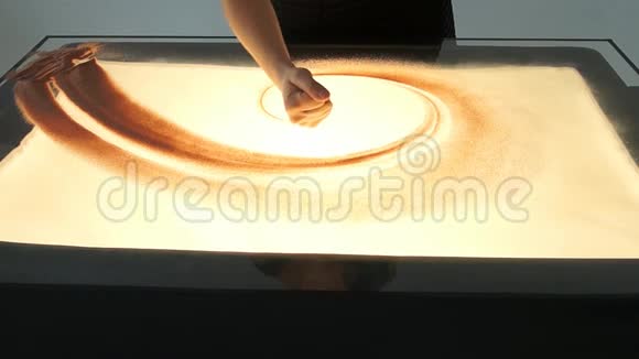 用沙子画画在白色的屏幕上画沙子沙滩艺术家双手画视频的预览图