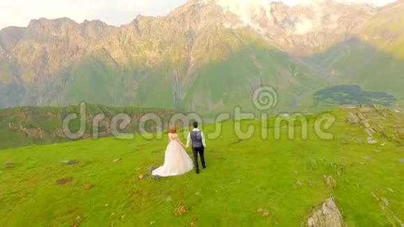 在群山的背景下幸福的新娘和新郎视频的预览图