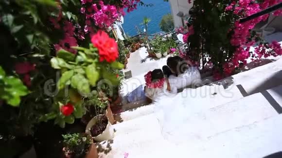 幸福的新娘和新郎在鲜花的背景下结婚纪念日视频的预览图
