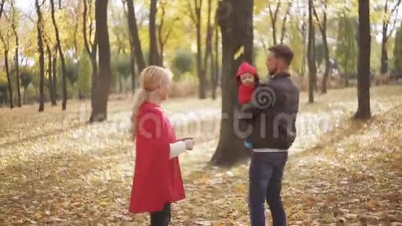 小幸福的家庭和小孩子在秋天公园玩耍视频的预览图