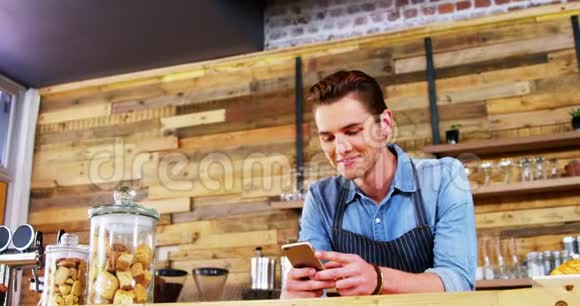 男服务员在柜台上用手机视频的预览图
