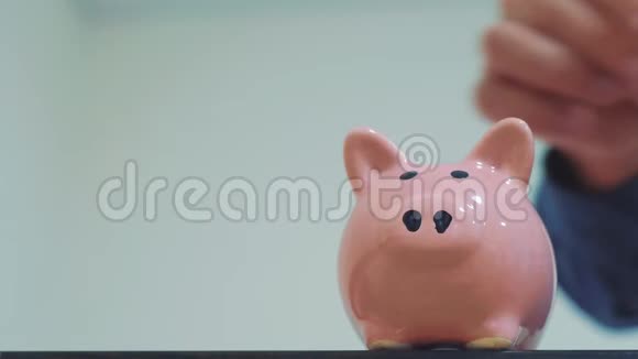 商人储蓄把硬币放在储蓄罐里猪银行的经营理念慢动作录像省钱就是视频的预览图