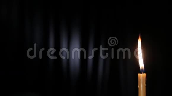 白色光束在黑色背景上燃烧的瘦蜡烛视频的预览图