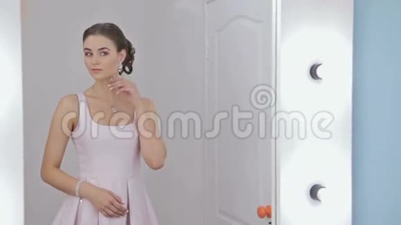 化妆的漂亮女人看着镜子里的倒影修头发视频的预览图