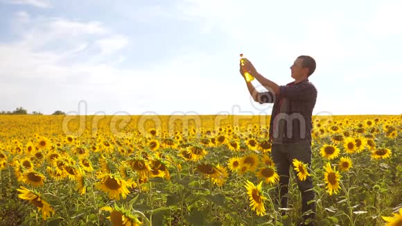 日落时分农夫手捧一瓶葵花籽油慢动作视频农民农业塑料视频的预览图