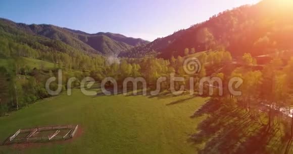 在阳光明媚的夏日早晨中气飞越新鲜的山河和草地农村土路下面视频的预览图