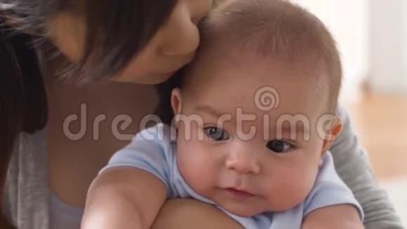 快乐的年轻妈妈在家亲吻小宝宝视频的预览图