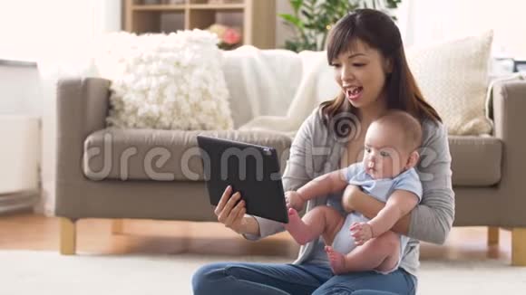 快乐的年轻妈妈带着婴儿和平板电脑回家视频的预览图