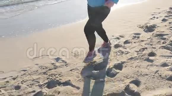 日落时分在海滩上奔跑的女人视频的预览图