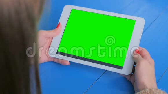 女人看着绿色屏幕的平板电脑视频的预览图