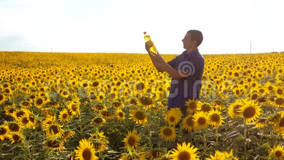 慢动作录像日落时分农夫手捧一瓶葵花籽油男子生活方式农民探索视频的预览图