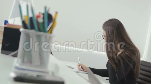 漂亮的女商人在办公室里用笔记本电脑工作视频的预览图