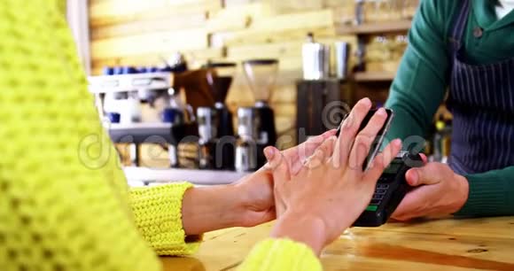 使用NFC技术的女性通过智能手机支付账单视频的预览图