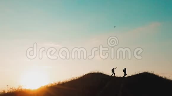 两个男子游客徒步旅行者剪影去山上日落旅游慢动作视频旅行成功的年轻人视频的预览图