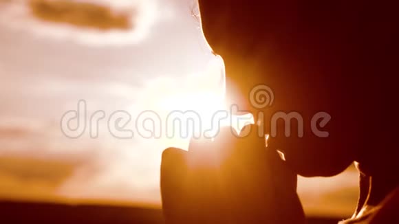 女孩祈祷女孩在日落时双手交叉祈祷剪影慢动作视频女孩双手合拢生活方式视频的预览图