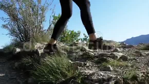 站在旅客的脚上妇女徒步行走在山顶悬崖在岩石上行走视频的预览图