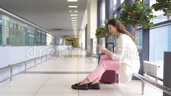 在国际机场等待航班的年轻女子视频的预览图