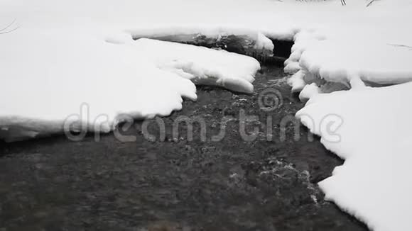 在公园里流着雪的水背景中的冰柱视频的预览图