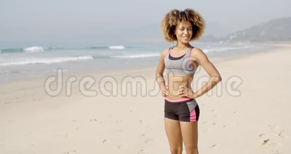 运动女站在海滩上视频的预览图