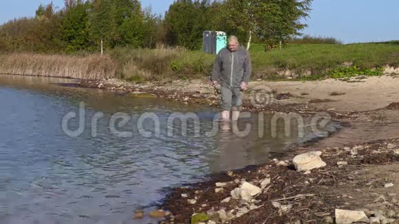 带着鱼竿在湖岸的人视频的预览图