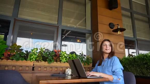 学生通过笔记本电脑与朋友在咖啡馆聊天视频的预览图