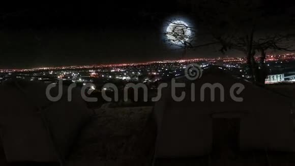 夜晚用月亮观赏城市景色的帐篷和树木视频的预览图