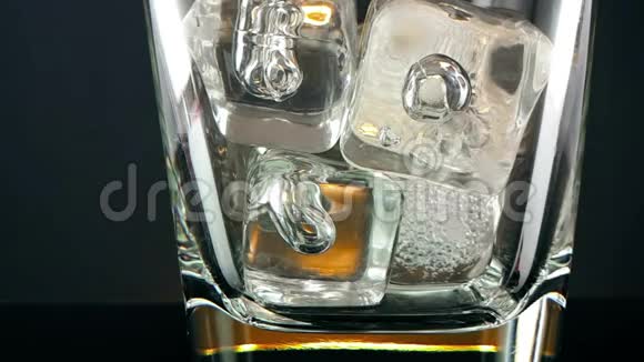 黑背景冰块的酒杯中的威士忌威士忌的放松时间视频的预览图