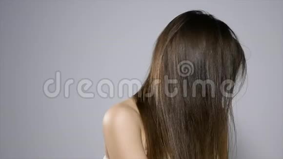 年轻漂亮的黑发女人在演播室里摆姿势一个漂亮女人的时尚肖像开朗的女人长棕色视频的预览图