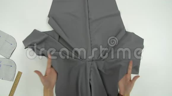 女性的手在灰色的布上展示一些东西视频的预览图