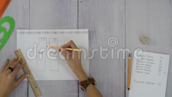 女性用手画一张裤子刺绣图视频的预览图