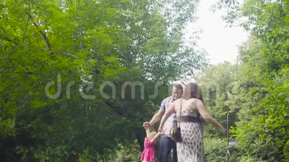 快乐的父母带着小女孩在公园视频的预览图