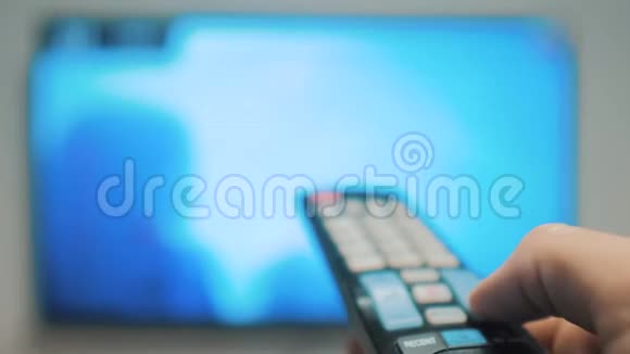 人手握电视遥控器关掉智能电视频道冲浪的生活方式紧紧抓住男人手里拿着电视视频的预览图