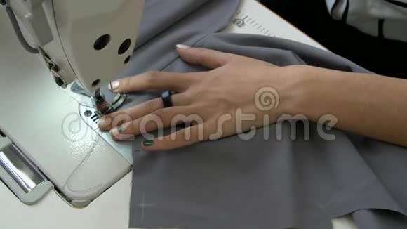 女性的手在缝纫机上缝制灰色织物视频的预览图