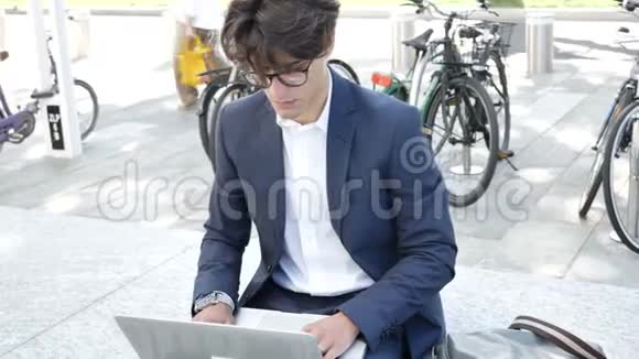 在电脑室外工作的英俊青年视频的预览图