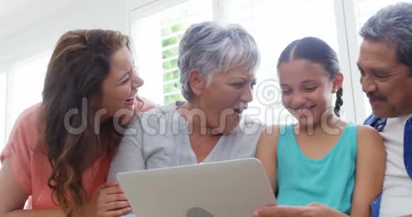 幸福的家庭坐在沙发上用笔记本电脑视频的预览图