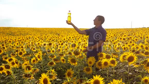 慢动作录像日落时分农夫手捧一瓶葵花籽油男子生活方式农民探索视频的预览图