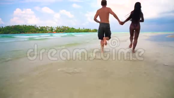 在阳光明媚的夏日跨种族的幸福夫妇在热带海滩享受蜜月视频的预览图
