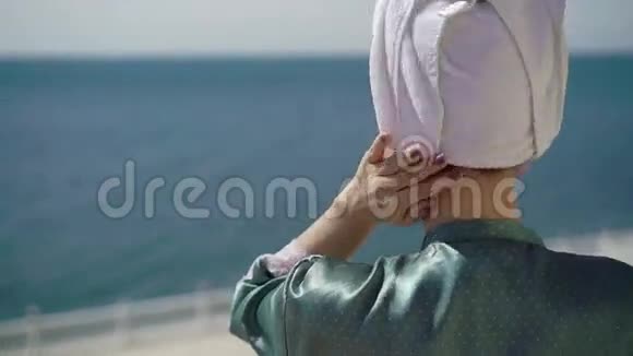 阳台上穿浴袍的年轻女子视频的预览图