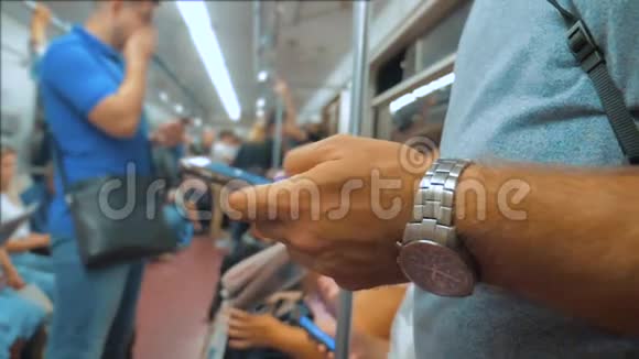 休闲男子从手机智能手机屏幕上阅读同时看导航员在地铁上旅行的生活方式视频的预览图