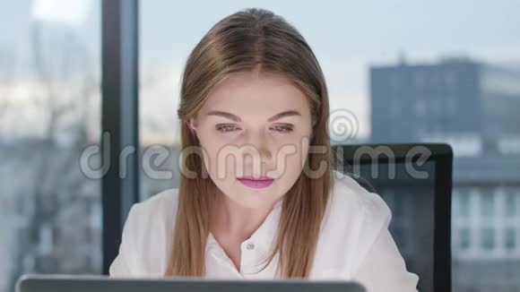 年轻漂亮的女士看着笔记本电脑视频的预览图