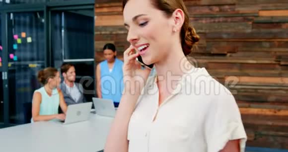 微笑的商务主管在用手机说话视频的预览图