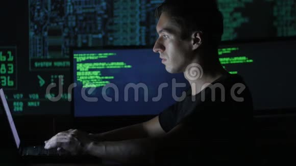 一位年轻的程序员在数据中心的一台电脑上工作的画像里面装满了显示屏视频的预览图