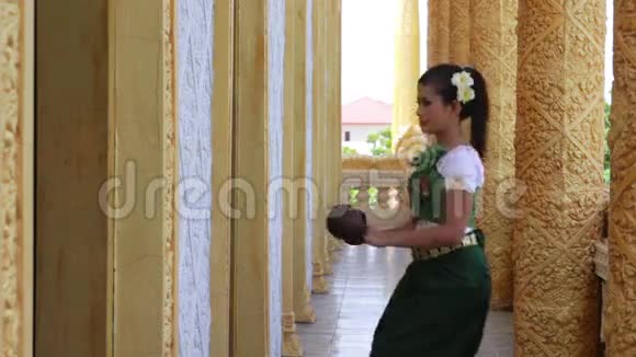 美丽的亚洲女孩在寺庙里表演椰子民间舞蹈视频的预览图